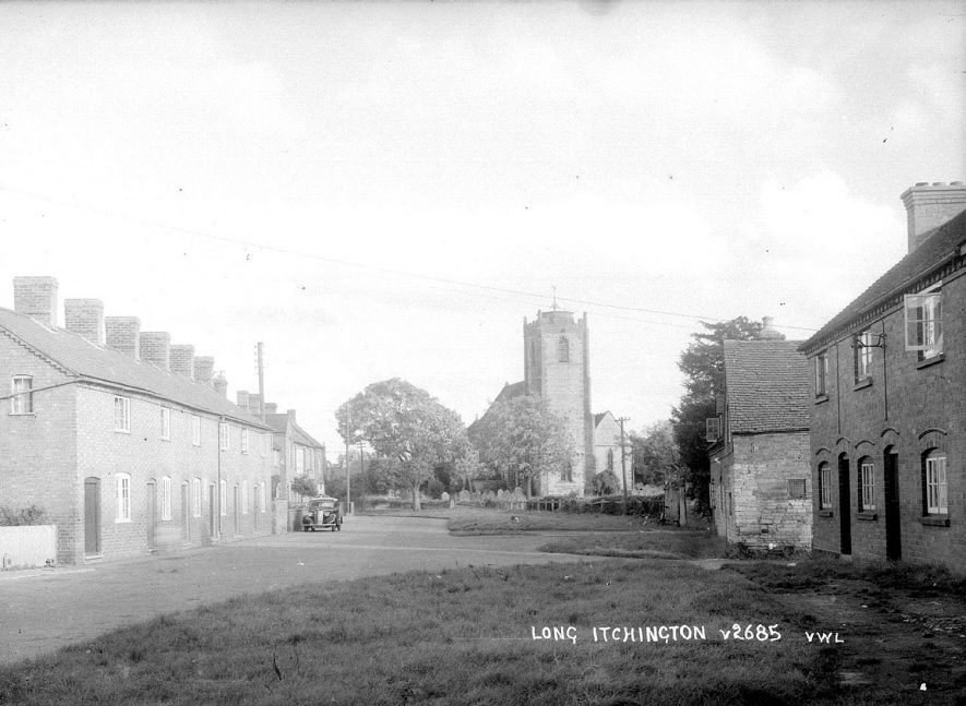 Road with terraced houses and Holy Trinity church in the background in Long Itchington.  1950s |  IMAGE LOCATION: (Warwickshire County Record Office)