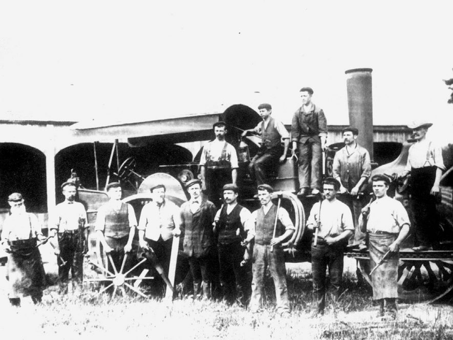 A group of Bomford and Evershed agricultural engineering workers in front of a steam engine, Salford Priors.  1900s |  IMAGE LOCATION: (Warwickshire County Record Office)