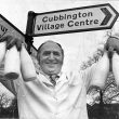Cubbington.  Milkman under village signpost