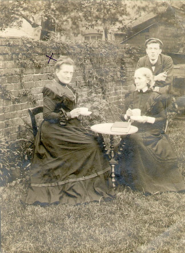 Two ladies and a man at a table in a garden in Stoneleigh. The lady on the left is Mrs Hopkins.  1900s |  IMAGE LOCATION: (Warwickshire County Record Office) PEOPLE IN PHOTO: Hopkins, Mrs, Hopkins as surname
