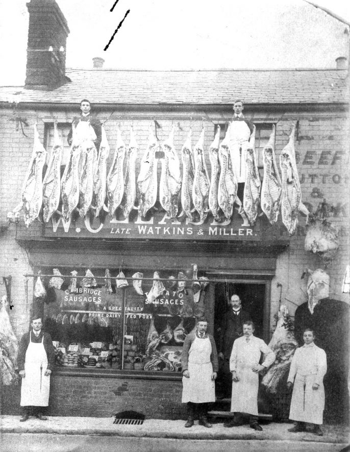 W. Cleasby's butchers shop with shop workers standing outside. Carcasses of meat are displayed outside the shop front. This shop was at 5 West Street, Rugby. This street is no longer in existence.  1911 |  IMAGE LOCATION: (Rugby Library)