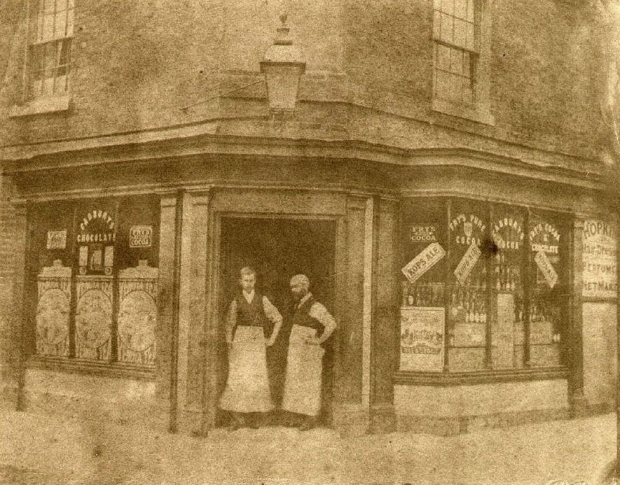 Grocery shop belonging to R.H. Whitehead, at the bottom of High Street, Alcester.  Two men are seen standing in the doorway.  1890s |  IMAGE LOCATION: (Warwickshire Museums. Photographic Collections.)