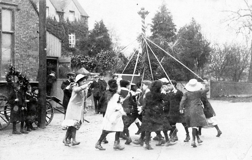 Children dancing round the maypole outside the church room in Southam Street, Kineton.  1908 |  IMAGE LOCATION: (Warwickshire Museums. Photographic Collections.)