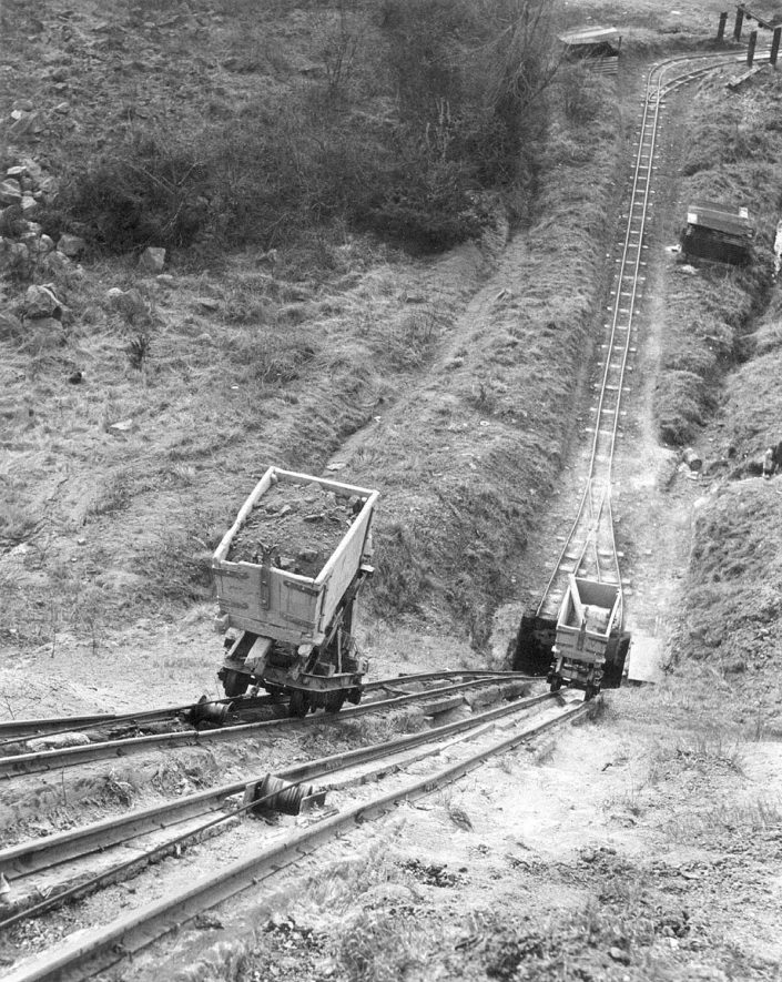 Trucks of clay being conveyed by 'line' from the Middle Lias Terrace to the works at ground level at the clay pits, Napton on the Hill.  1950s |  IMAGE LOCATION: (Warwickshire Museums. Photographic Collections.)