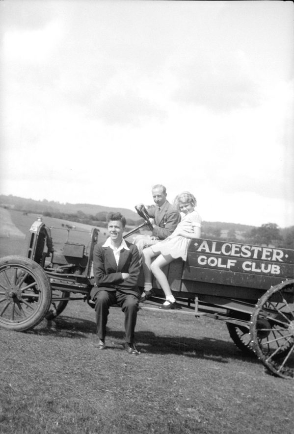 Grass-cutting vehicle on Alcester golf course.  Two men and girl seated on it.  1950s |  IMAGE LOCATION: (Warwickshire County Record Office)