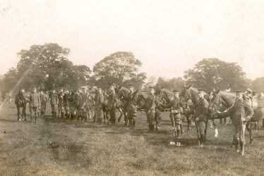 Warwick.  Troop of dismounted cavalry in a park
