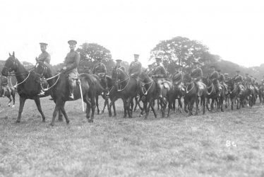 Warwick.  Troop of mounted cavalry in a park