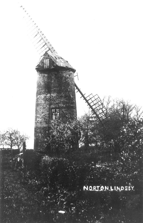 Windmill, Norton Lindsey. 1900sPreserved small,(42ft (c.12.8m) high 18ft (c.5.5m) base diameter), 3 storey, red brick tower with slight batter built c.1795. Had 4 common sails. Steam power added 1889. Last worked 1906.Two stocks with fragments of common sails, boat cap with luffing wheel at tail, 2 pairs stones & all main machinery with pulley wheel on outside for steam drive.New cap 1977. |  IMAGE LOCATION: (Warwickshire County Record Office)