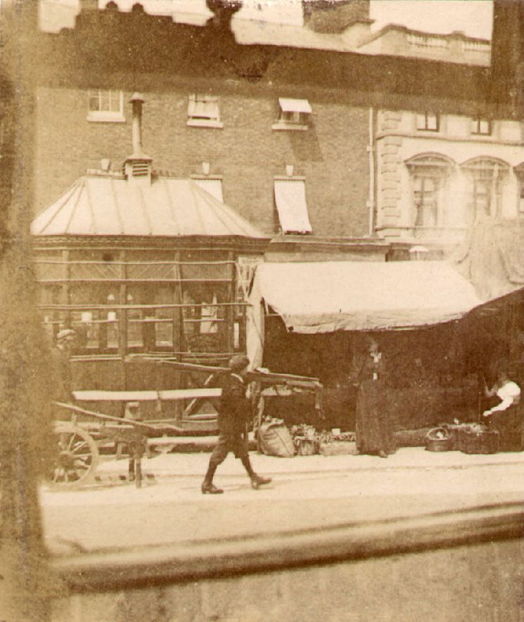 Market stall and shops in Market Place, Rugby.  1890s |  IMAGE LOCATION: (Warwickshire County Record Office)