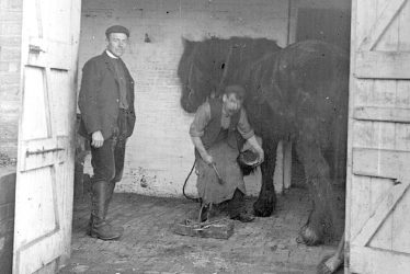Clifford Chambers.  Blacksmith shoeing a horse