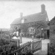 Cubbington.  Mrs Wells in front of her cottage