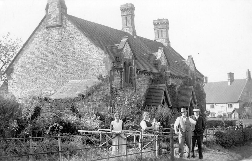 Stone cottages with front gardens, Combrook, showing two men and two women.  1910s |  IMAGE LOCATION: (Warwickshire County Record Office)