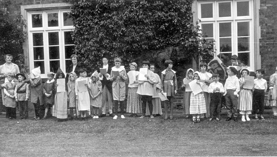 A pageant being performed in the grounds of the old vicarage, Grandborough.  From left to right: P Graham, R Campion, P Timms, N Cole, R Paget, C Witney, S Dingley, B Witney, J C Hapman, L Slade, J Slade, G Hopkins, C Timms, H Berry, C Campion, L Morgan, E Dunkley, R Holland, T Fletcher, H Chapman, R Powell, P Graham, F Graham and I Mackay.  July 1962 |  IMAGE LOCATION: (Warwickshire County Record Office) PEOPLE IN PHOTO: Witney, C, Witney, B, Witney as a surname, Timms, P, Timms, C, Timms as a surname, Slade, L, Slade, J, Slade as a surname, Powell, R, Powell as a surname, Paget, R, Paget as a surname, Morgan, L, Morgan as a surname, Mackay, I, Mackay as a surname, Hopkins, G, Hopkins as surname, Holland, R, Holland as a surname, Graham, P, Graham, F, Graham as a surname, Fletcher, T, Fletcher as a surname, Dunkley, E, Dunkley as a surname, Dingley, S, Dingley as a surname, Cole, N, Cole as a surname, Chapman, J, Chapman, H, Chapman as a surname, Campion, R, Campion, C, Campion as a surname, Berry, H, Berry as a surname