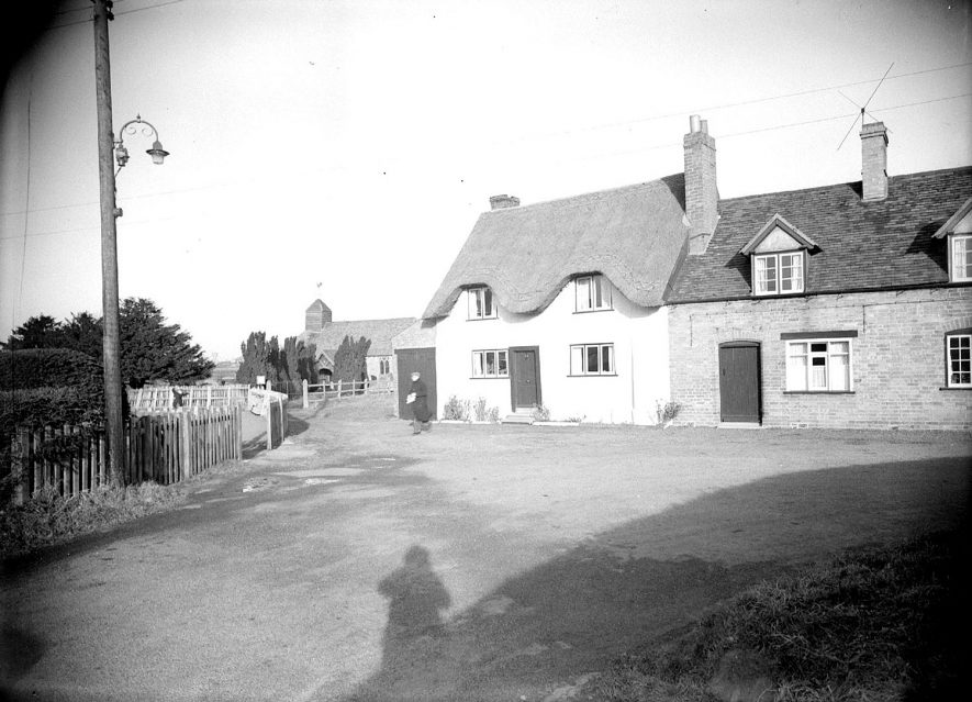 Cottages and St Margaret's church, Hunningham in the background.  1938 |  IMAGE LOCATION: (Warwickshire County Record Office)