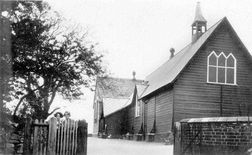 Exterior of The Church of the Resurrection, Hurley. Two girls are seen looking over the fence.  1930s |  IMAGE LOCATION: (Warwickshire County Record Office)