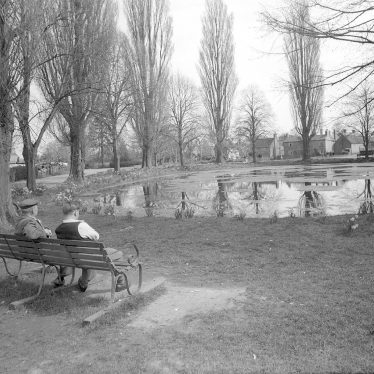 Long Itchington village pond, with two men sitting on a seat.  April 24th 1956 |  IMAGE LOCATION: (Warwickshire County Record Office)