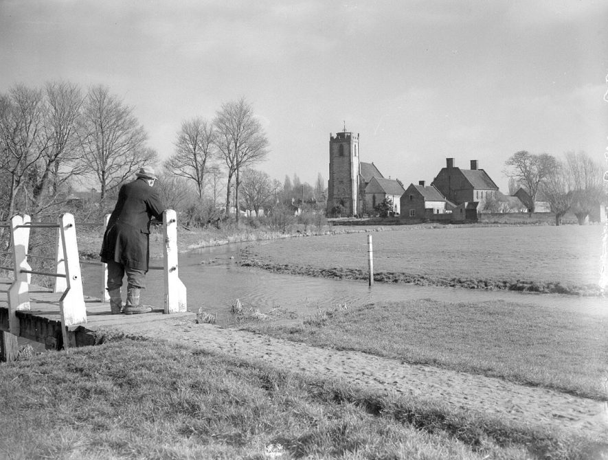 Holy Trinity church and River Itchen, Long Itchington. A man is standing on the footbridge looking towards the church.  February 26th 1953 |  IMAGE LOCATION: (Warwickshire County Record Office)