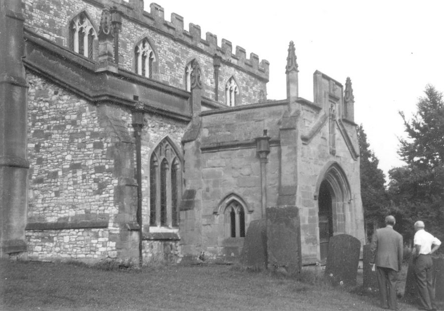 Church of St Botolph, showing porch and part of south side and two men, Newbold on Avon.  1950s |  IMAGE LOCATION: (Warwickshire County Record Office)