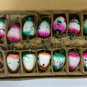 Christmas tree lights (inside the box). The lights are mostly white in colour, and have different coloured tops and tails. There are 17 in the box in total. | Image courtesy of Warwickshire Museum