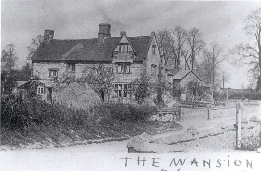 The Mansion, Bishops Itchington in the early 1900s. A back and white image of the house, which has a timber framed gable at the front right. beneath the image is written 'The Mansion' in pen. | Image courtesy of Bill Sutton