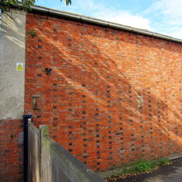 Fenny Compton former Primitive Methodist Chapel side view, 2017. Mostly red brick side wall with black brick columns, no windows | Image courtesy of Anne Langley