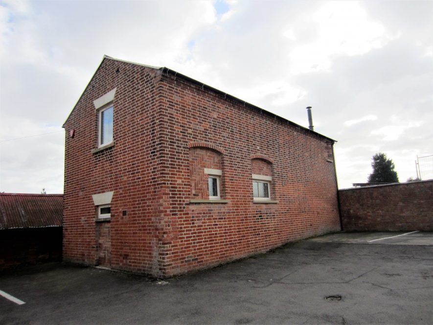 Former Baptist Chapel in Pailton, 2017. Small red brick building with bricked up door and window above on front wall; side wall has 2 arched, bricked up former windows (with smaller windows added later) | Image courtesy of Anne Langley