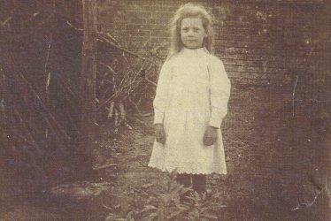 Ladbroke.  Child outside Church Cottages.