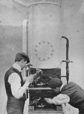 Photograph of Thomas Brooks (the uncle of Ernest G Brooks) chipping out the scale of a Victor No.13 gas fired boiler, c.1910 | Photographer H.J. Hare & Son Ltd, Lincoln Studios. Potterton, Boiler Manufacturers collection, Warwickshire County Record Office reference CR4765/165