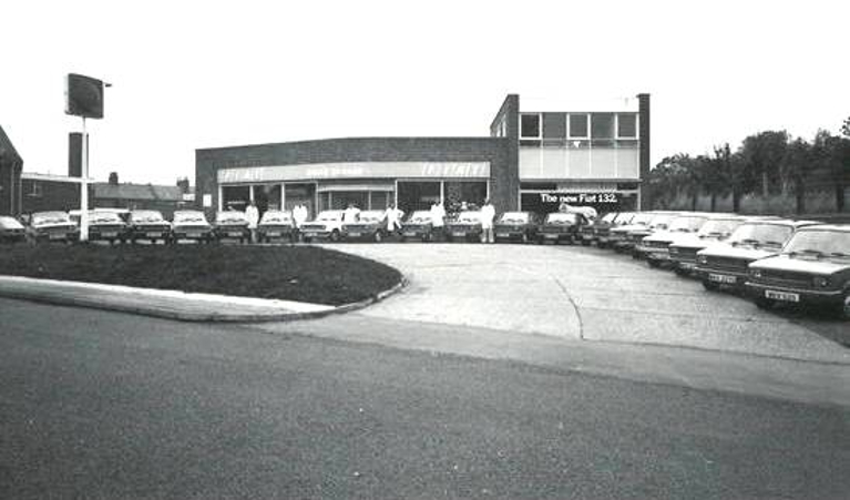 Grays Garage Ltd of Wharf Street, Warwick, Warwickshire, selling Fiats. 1978. A forecourt shows a number of cars, along with a sign for the garage. | Image courtesy of Grays Garage Ltd