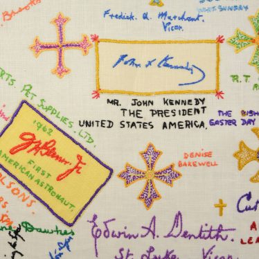 Detail from embroidered friendship cloth, showing signatures of John F Kennedy and astronaut John Glenn. | Image courtesy of Warwickshire Museum