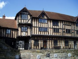 Lord Leycester's Hospital, Warwick, 2006. 3-storey timber-framed building with jetted 1st floor and tiled roof. Statue of bear & ragged staff over a wooden door, set up above a stone wall | Image courtesy of Anne Langley