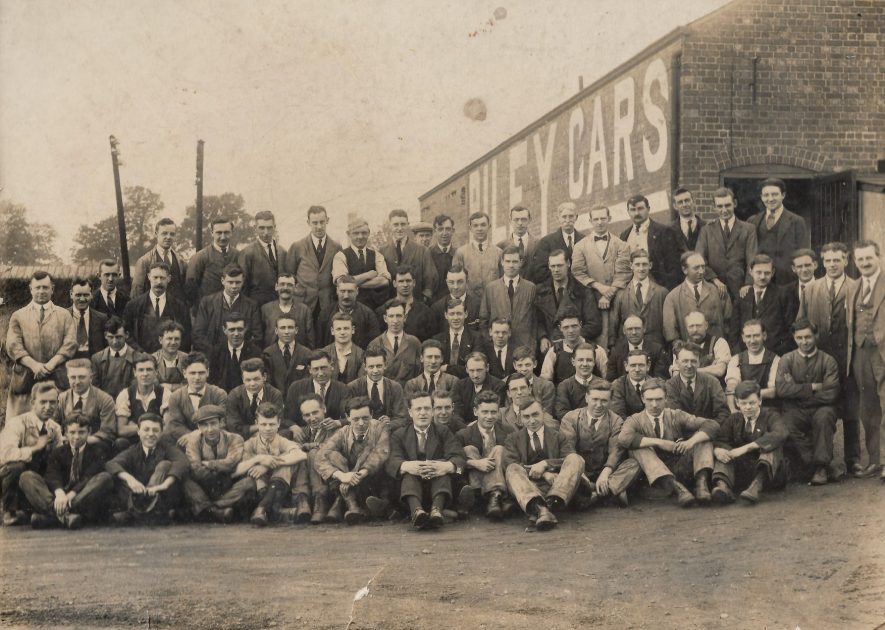 Coventry. Riley car factory staff, 1932. Roland Stocker (three from the right, third row), with his colleagues outside the Riley car factory. The site is down Durbar Avenue, off Foleshill Road in Coventry. The building is still there and is occupied by another company who manufacture and supply automotive parts. | Image courtesy of Peter Stocker