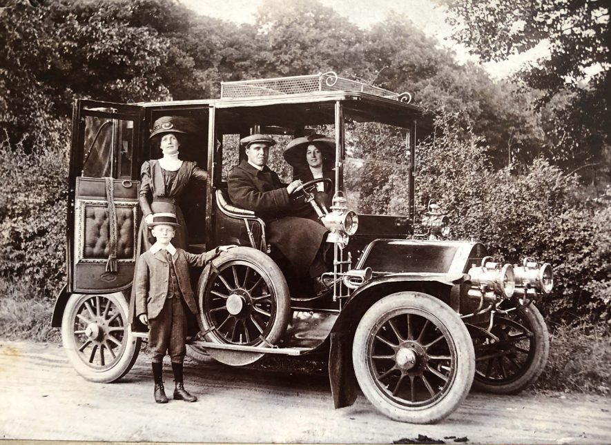 Tom Herring driving a car with landaulet bodywork in 1911. His future wife Ivy Francis is sat i the passenger seat. Tom worked at Mains Garage in Leamington Spa and served as a Mechanic with Royal Flying Corps in WW1. | Image courtesy of Derek Bull