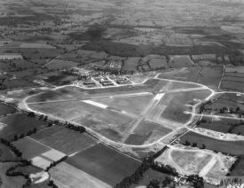 Royal Air Force Bomber Command, 1939-1941. (HU 93064) Oblique aerial view of RAF Wellesbourne Mountford, Warwickshire, from north-north-west. Vickers Wellingtons of No. 22 Operational Training Unit can be seen occupying some of the circular dispersals off the perimeter track. The building of the technical site (middle) is almost complete, with the exception of one of four Type T2 hangars, which is still under construction. | Copyright: © IWM. Original Source: https://www.iwm.org.uk/collections/item/object/205023547